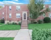 Colonial-style house with a front lawn and brick siding Colonial-style house with a front lawn and brick siding