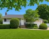 Ranch-style residence featuring light-toned siding and a dark shingle roof Ranch-style residence featuring light-toned siding and a dark shingle roof