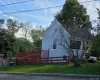 View of side of property featuring a chimney and a wooden deck View of side of property featuring a chimney and a wooden deck