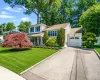 Manicured front lawn with mature plantings, garage Manicured front lawn with mature plantings, garage