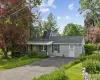 Ranch-style residence featuring light gray siding, a dark green shingle roof, and a solar panel installation Ranch-style residence featuring light gray siding, a dark green shingle roof, and a solar panel installation