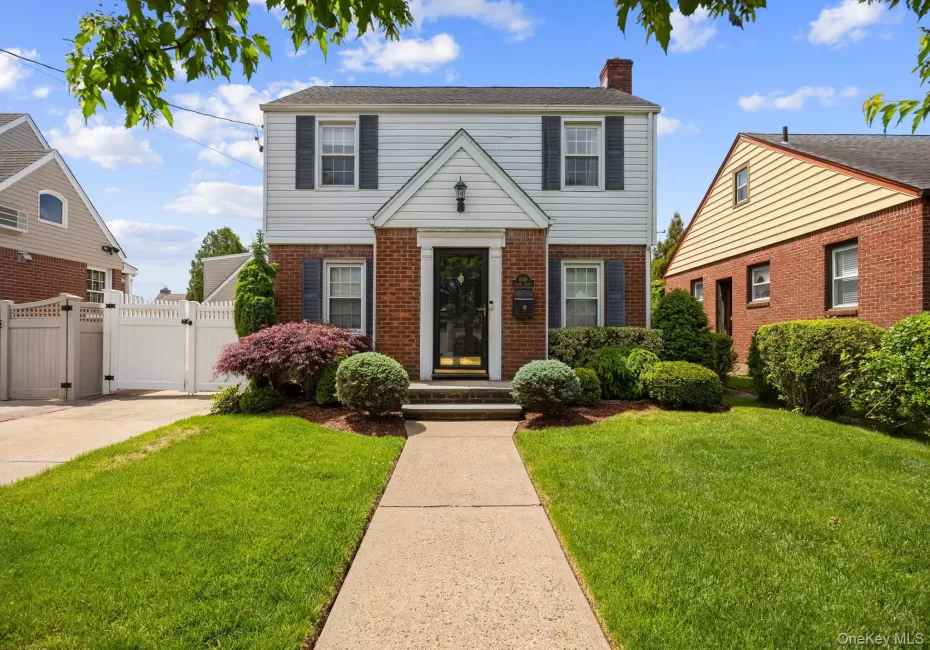 Two-story residence featuring a brick and siding facade, black window shutters, and a central entryway. Two-story residence featuring a brick and siding facade, black window shutters, and a central entryway.