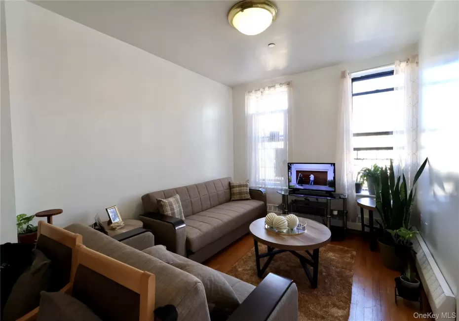 Living area with a baseboard heating unit and hardwood / wood-style floors Living area with a baseboard heating unit and hardwood / wood-style floors