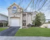 View of front of property with stucco siding, asphalt driveway, and a garage View of front of property with stucco siding, asphalt driveway, and a garage