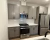 Kitchen featuring light gray shaker-style cabinetry, white subway tile backsplash, white quartz countertops, and stainless steel appliances. Kitchen featuring light gray shaker-style cabinetry, white subway tile backsplash, white quartz countertops, and stainless steel appliances.