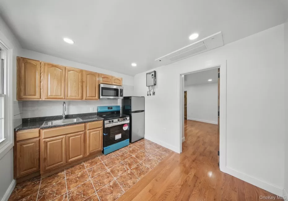 Kitchen featuring stainless steel appliances, a sink, dark countertops, baseboards, and recessed lighting Kitchen featuring stainless steel appliances, a sink, dark countertops, baseboards, and recessed lighting