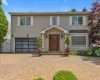 Two-story residence siding, a prominent wood entry door with sidelights, and a bay window Two-story residence siding, a prominent wood entry door with sidelights, and a bay window