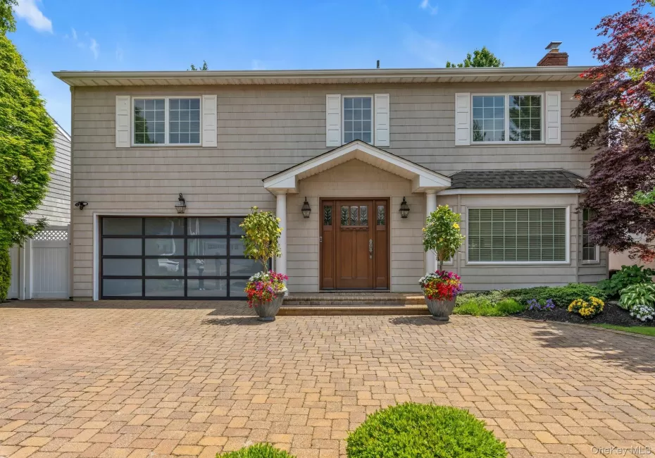 Two-story residence siding, a prominent wood entry door with sidelights, and a bay window Two-story residence siding, a prominent wood entry door with sidelights, and a bay window