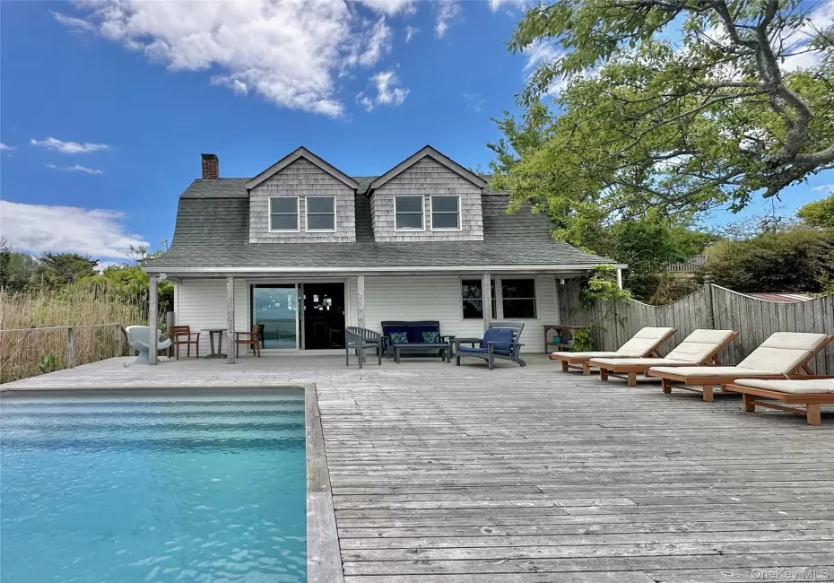 Rear view of property with a deck, a chimney, roof with shingles, and outdoor lounge area Rear view of property with a deck, a chimney, roof with shingles, and outdoor lounge area