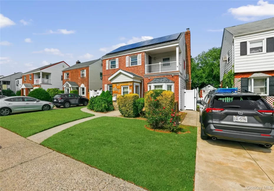 Brick exterior residence featuring a front lawn and paved driveway Brick exterior residence featuring a front lawn and paved driveway