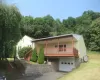 View of front of home featuring a porch, stairway, driveway, an attached garage, and heating fuel View of front of home featuring a porch, stairway, driveway, an attached garage, and heating fuel