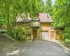 Rustic exterior featuring a deck, two garage bays, and a secondary balcony Rustic exterior featuring a deck, two garage bays, and a secondary balcony
