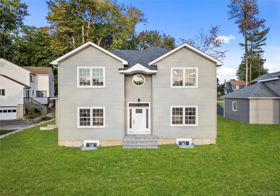 Traditional-style home with a front yard and entry steps Traditional-style home with a front yard and entry steps