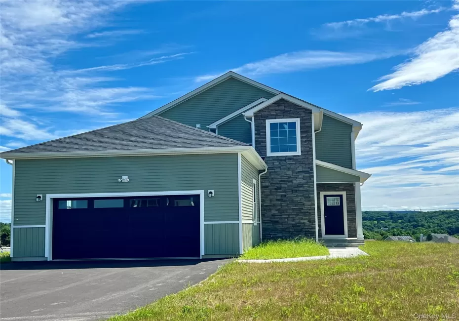 View of front of house featuring driveway, a garage, and stone siding View of front of house featuring driveway, a garage, and stone siding
