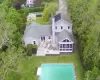 Back of house featuring a deck, a yard, a shingled roof, and a sunroom Back of house featuring a deck, a yard, a shingled roof, and a sunroom