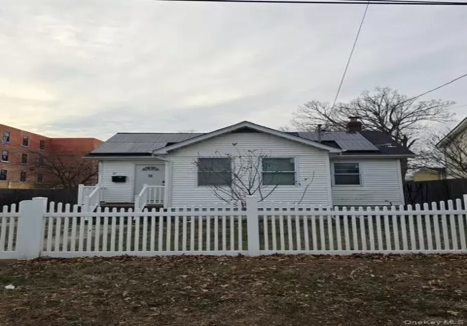 Bungalow-style home featuring a chimney, solar panels, and a fenced front yard Bungalow-style home featuring a chimney, solar panels, and a fenced front yard