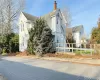 View of side of property featuring a chimney and a fenced front yard View of side of property featuring a chimney and a fenced front yard