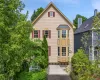 Traditional Contemporary-style exterior featuring light-colored siding, a prominent bay window, and red window shutters Traditional Contemporary-style exterior featuring light-colored siding, a prominent bay window, and red window shutters