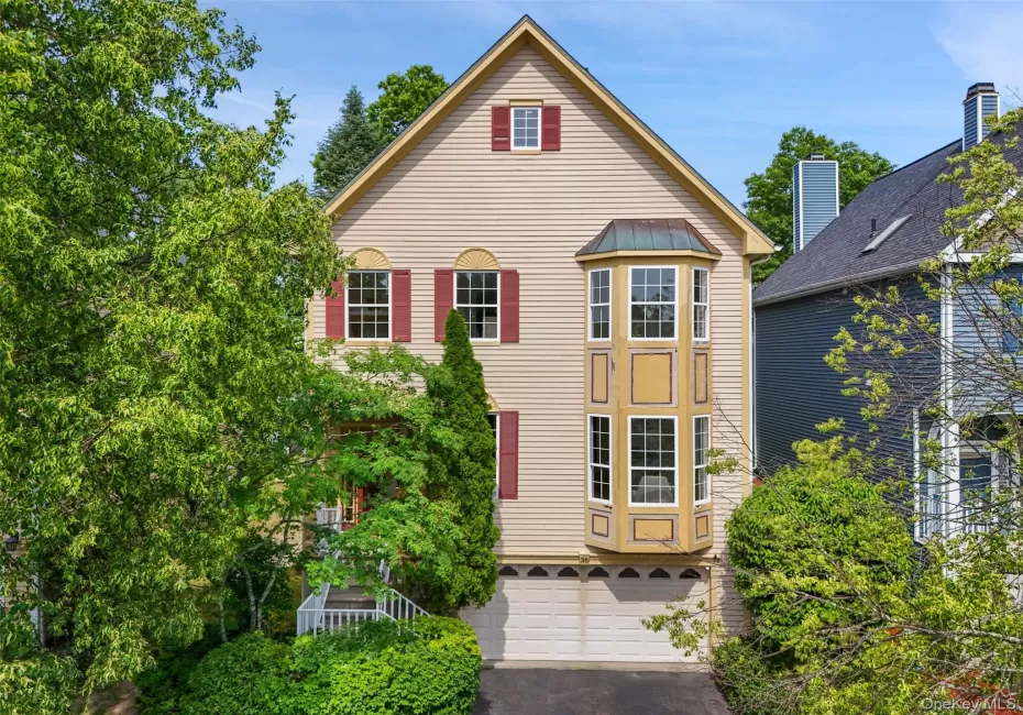 Traditional Contemporary-style exterior featuring light-colored siding, a prominent bay window, and red window shutters Traditional Contemporary-style exterior featuring light-colored siding, a prominent bay window, and red window shutters