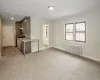 Kitchen with radiator, light colored carpet, light countertops, and baseboards Kitchen with radiator, light colored carpet, light countertops, and baseboards