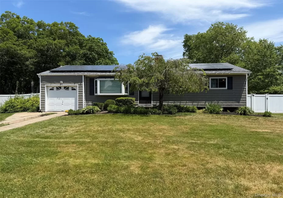 Ranch-style residence featuring grey siding, a front-facing garage with a white door, and a bay window Ranch-style residence featuring grey siding, a front-facing garage with a white door, and a bay window