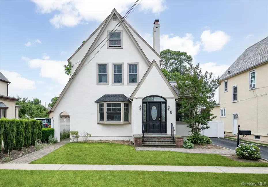 Gable-roof exterior with white stucco finish and contrasting trim Gable-roof exterior with white stucco finish and contrasting trim
