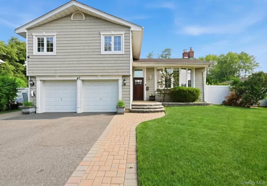 Split-level residence featuring light-colored siding and white trim Split-level residence featuring light-colored siding and white trim