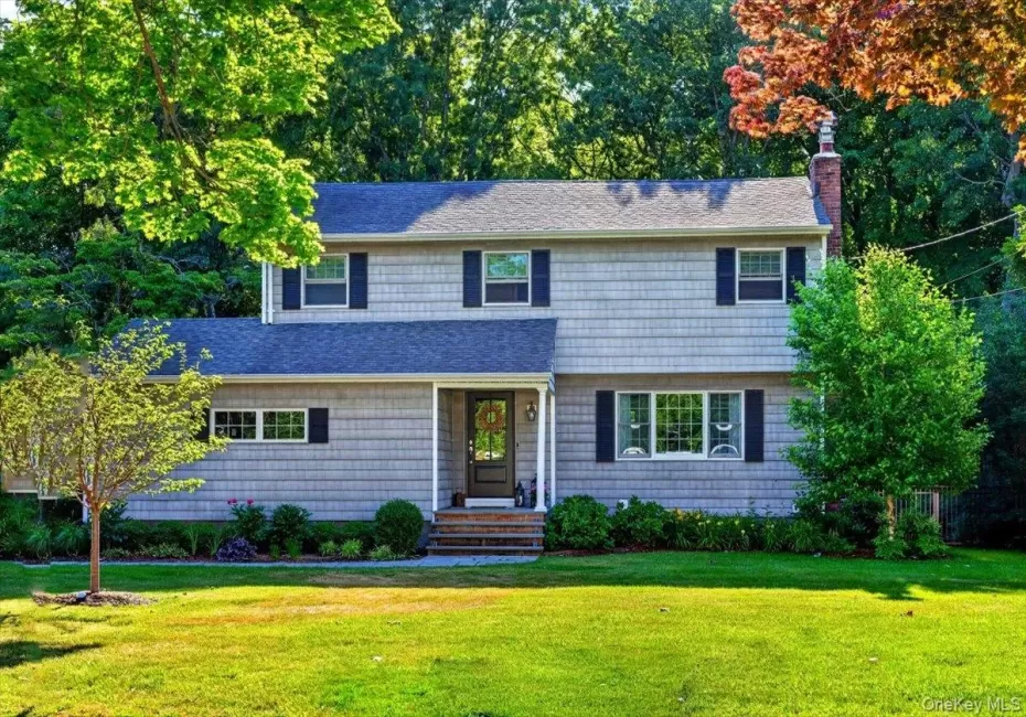 Two-story residence featuring horizontal siding, a dark roof, and contrasting shutters Two-story residence featuring horizontal siding, a dark roof, and contrasting shutters