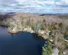 Aerial view of property's location with a heavily wooded area and a mountain backdrop Aerial view of property's location with a heavily wooded area and a mountain backdrop