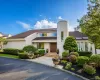 Contemporary stucco exterior featuring a prominent cylindrical tower with vertical window, double wooden entry doors, and a stone-paved walkway Contemporary stucco exterior featuring a prominent cylindrical tower with vertical window, double wooden entry doors, and a stone-paved walkway