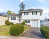 Tri-level home featuring a chimney, driveway, an attached garage, and roof with shingles Tri-level home featuring a chimney, driveway, an attached garage, and roof with shingles