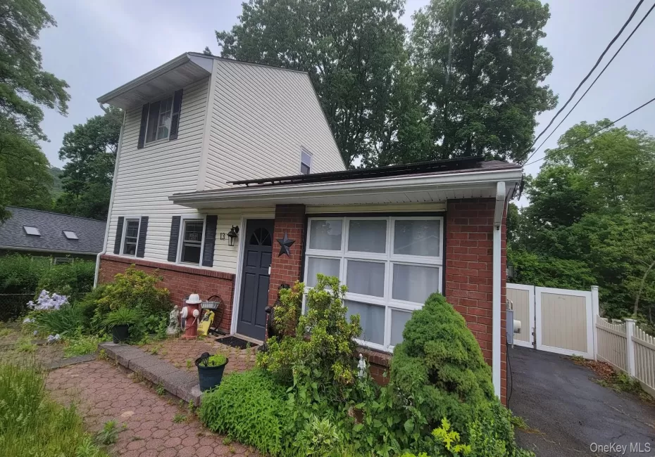 Split-level residence featuring a brick facade and light-colored siding Split-level residence featuring a brick facade and light-colored siding