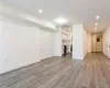Unfurnished living room with light wood finished floors, visible vents, baseboards, recessed lighting, and a sink Unfurnished living room with light wood finished floors, visible vents, baseboards, recessed lighting, and a sink
