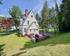 White-sided residence featuring a red brick chimney and a multi-level wood deck White-sided residence featuring a red brick chimney and a multi-level wood deck