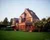 Back of property featuring a sunroom, a lawn, and a chimney Back of property featuring a sunroom, a lawn, and a chimney