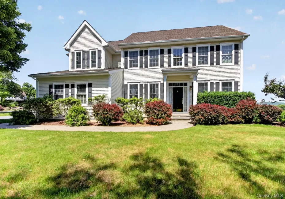 Traditional-style residence featuring light-colored siding and a dark roof Traditional-style residence featuring light-colored siding and a dark roof