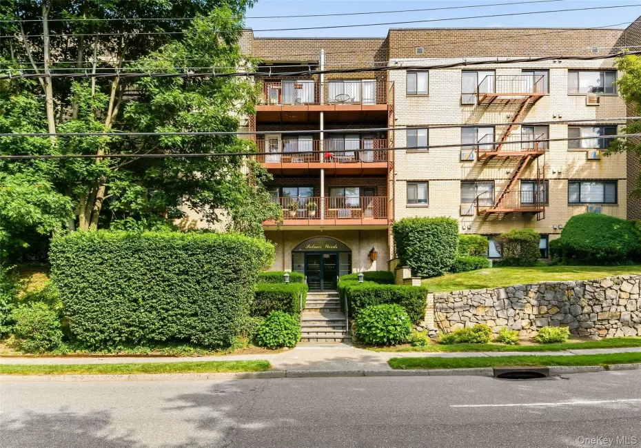 Multi-story residential building featuring a light-colored brick facade. Multi-story residential building featuring a light-colored brick facade.