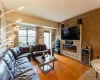 Spacious living room featuring hardwood floors, decorative faux stone accent wall, electric fireplace, and direct access to the private balcony. Spacious living room featuring hardwood floors, decorative faux stone accent wall, electric fireplace, and direct access to the private balcony.