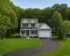 View of front facade featuring driveway, a front yard, a garage, and a porch View of front facade featuring driveway, a front yard, a garage, and a porch