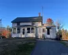 View of front facade featuring a chimney and a front yard View of front facade featuring a chimney and a front yard