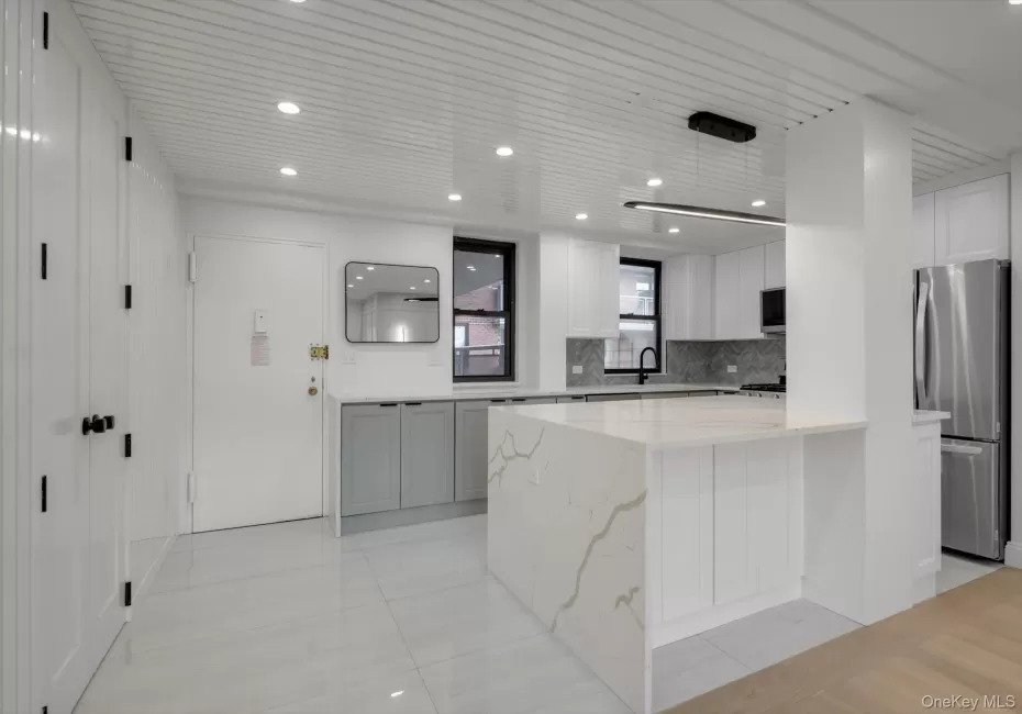 Kitchen featuring stainless steel appliances, tasteful backsplash, light stone counters, white cabinets, and recessed lighting Kitchen featuring stainless steel appliances, tasteful backsplash, light stone counters, white cabinets, and recessed lighting