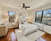 Bedroom with radiator, hardwood flooring, ceiling fan, and cooling unit Bedroom with radiator, hardwood flooring, ceiling fan, and cooling unit