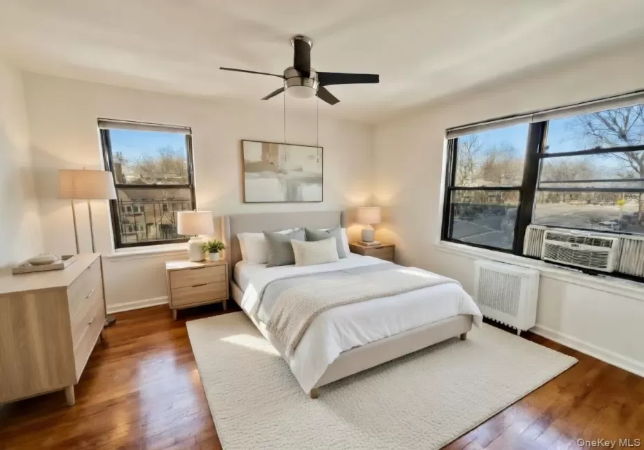 Bedroom with radiator, hardwood flooring, ceiling fan, and cooling unit Bedroom with radiator, hardwood flooring, ceiling fan, and cooling unit