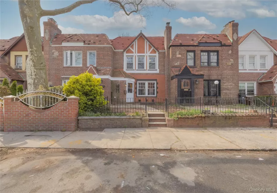 Charming brick facade featuring a gabled roofline, multiple white-framed windows, contrasting terracotta-colored stucco detailing, and a traditional front door with an exterior sconce. The covered entry showcases a tiled roof, while the front yard is enhanced by mature shrubbery and landscaped curb appeal. Charming brick facade featuring a gabled roofline, multiple white-framed windows, contrasting terracotta-colored stucco detailing, and a traditional front door with an exterior sconce. The covered entry showcases a tiled roof, while the front yard is enhanced by mature shrubbery and landscaped curb appeal.