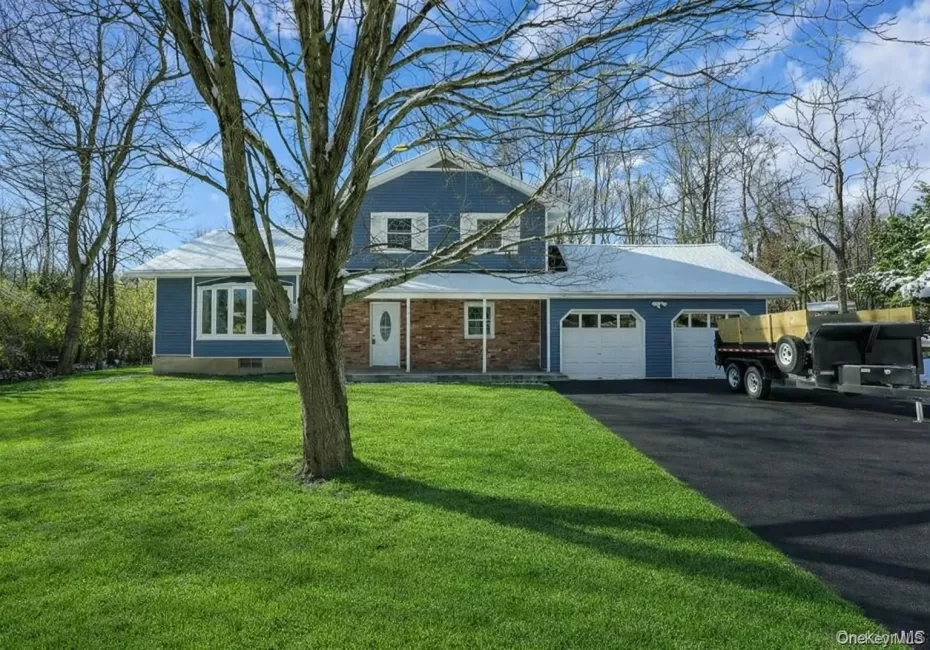 View of front of house with a garage, a front yard, asphalt driveway, and brick siding View of front of house with a garage, a front yard, asphalt driveway, and brick siding