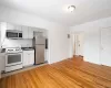 Kitchen with appliances with stainless steel finishes, light wood finished floors, dark countertops, and white cabinetry Kitchen with appliances with stainless steel finishes, light wood finished floors, dark countertops, and white cabinetry