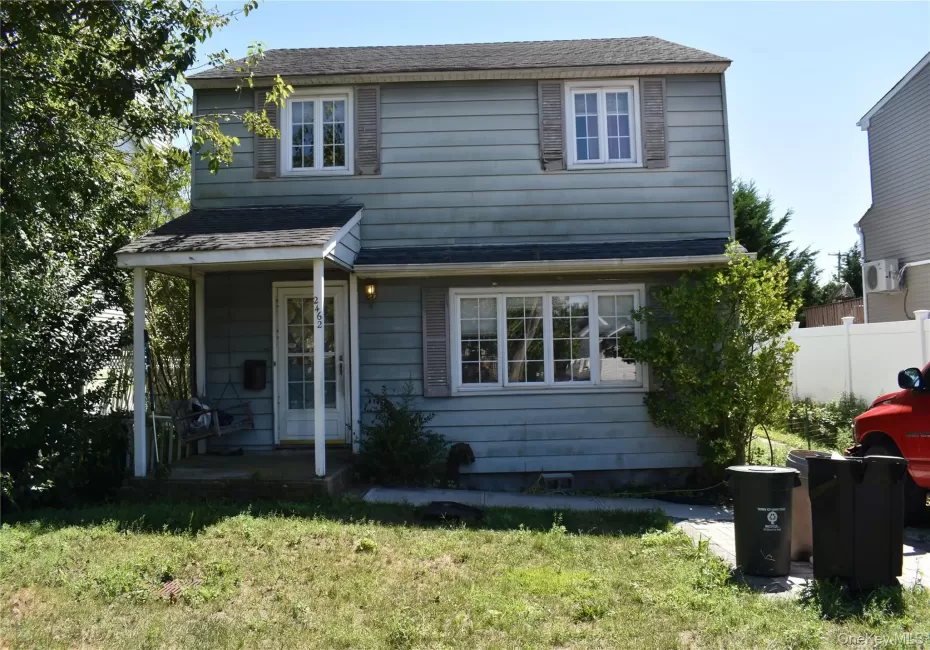 View of front facade with roof with shingles, a front yard, and covered porch View of front facade with roof with shingles, a front yard, and covered porch