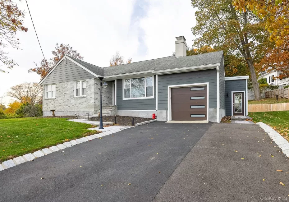 View of front of house featuring a front lawn, asphalt driveway, a chimney, a garage, and a shingled roof View of front of house featuring a front lawn, asphalt driveway, a chimney, a garage, and a shingled roof