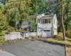 View of front of home featuring asphalt driveway, a garage, and view of wooded area View of front of home featuring asphalt driveway, a garage, and view of wooded area