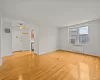 Unfurnished room featuring light wood-style flooring, radiator heating unit, and ceiling fan Unfurnished room featuring light wood-style flooring, radiator heating unit, and ceiling fan